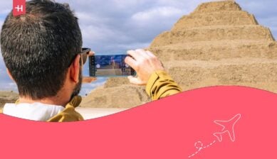 سائح يستخدم هاتفه الذكي لتصوير هرم زوسر المدرج القديم في سقارة بمصر.