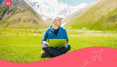 رجل يعمل على حاسوبه المحمول وسط جبال جورجيا الخضراء، يستخدم أفضل شريحة إلكترونية جورجيا للبقاء متصلاً بالإنترنت