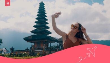 مسافرة تلتقط صورة سيلفي أمام معبد تقليدي في بالي، إندونيسيا.