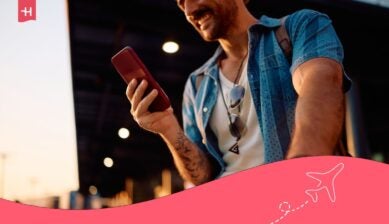 رجل يستخدم هاتفه أثناء السفر للبحث عن طريقة تجنُّب رسوم التجوال عند السفر وتفادي تكاليف الاتصال المرتفعة.