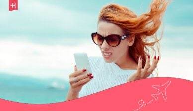 مسافرة تنظر بانزعاج إلى هاتفها الذكي أثناء محاولة استخدام شريحة eSIM من Saily.