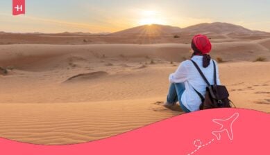 مسافرة تستمتع بغروب الشمس فوق الكثبان الرملية في تونس، في سياق البحث عن سعر شريحة الهاتف في تونس