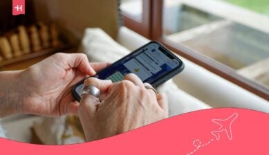 شخص يستخدم تطبيق واتساب على هاتف ذكي قرب نافذة.