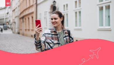 Foto di una graziosa giovane donna con lo zaino che rimane per strada tenendo il telefono in mano