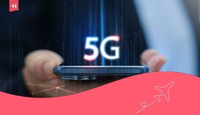 يد تحمل هاتفاً ذكياً يظهر عليه أيقونة شبكة الجيل الخامس (5G) وواجهة شبكة عالمية.