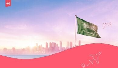 علم المملكة العربية السعودية يرفرف أمام مشهد خلاب لأفق مدينة عصري.