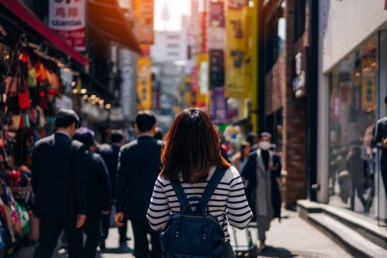 一位年轻的亚洲女游客在韩国首尔明洞街头市场购物。