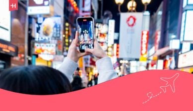 女游客在道顿堀（Dotonbori）与著名的夜市街头小吃合影。