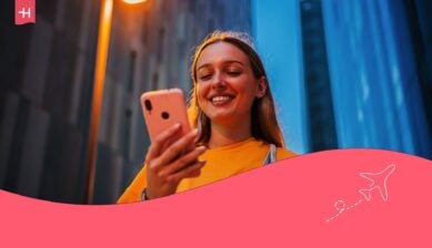 En kvinne som smiler til telefonen sin, som hovedbilde til en artikkel om Ice eSIM