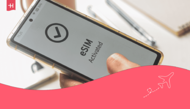 Et bilde av en person som holder en smarttelefon der ordet «eSIM» vises på skjermen, som hovedbilde til en Nomad eSIM-anmeldelse