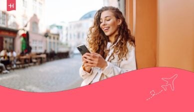 En kvinne som står i gata og ser på telefonen sin, som hovedbilde til en artikkel om OneCall eSIM