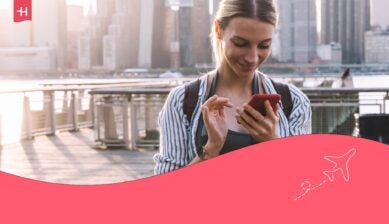 Kvinne i en by som ser på telefonen sin, som hovedbilde til en artikkel om Talkmore eSIM