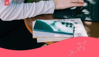 Smarttelefon på bord ved siden av laptop, brukt som illustrasjon i guide om Jetpac eSIM og mobiltilkobling på reise.