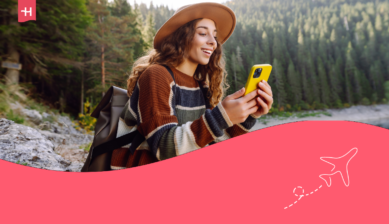 Smilende kvinne som ser på telefonen sin – utvalgt bilde til en anmeldelse av Unifon eSIM