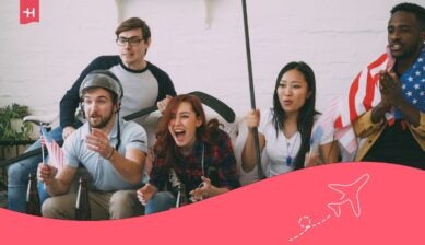 En engasjert gruppe venner som sitter i en sofa og heier ivrig med flagg og sportsutstyr, noe som illustrerer stemningen under verdens største idrettsarrangement. Nederst er et rosa grafisk element med et hvitt flyikon.